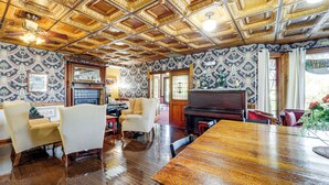 A spacious room with a wooden ceiling, a piano, and a large wooden table. - 'the Pickford House' - Luxury Central Coast Stay! (Cambria)