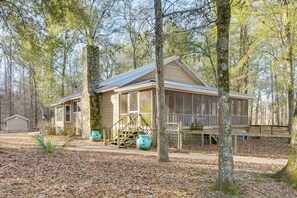 Eine Hütte mit Veranda, Satellitenschüssel und Holzterrasse.