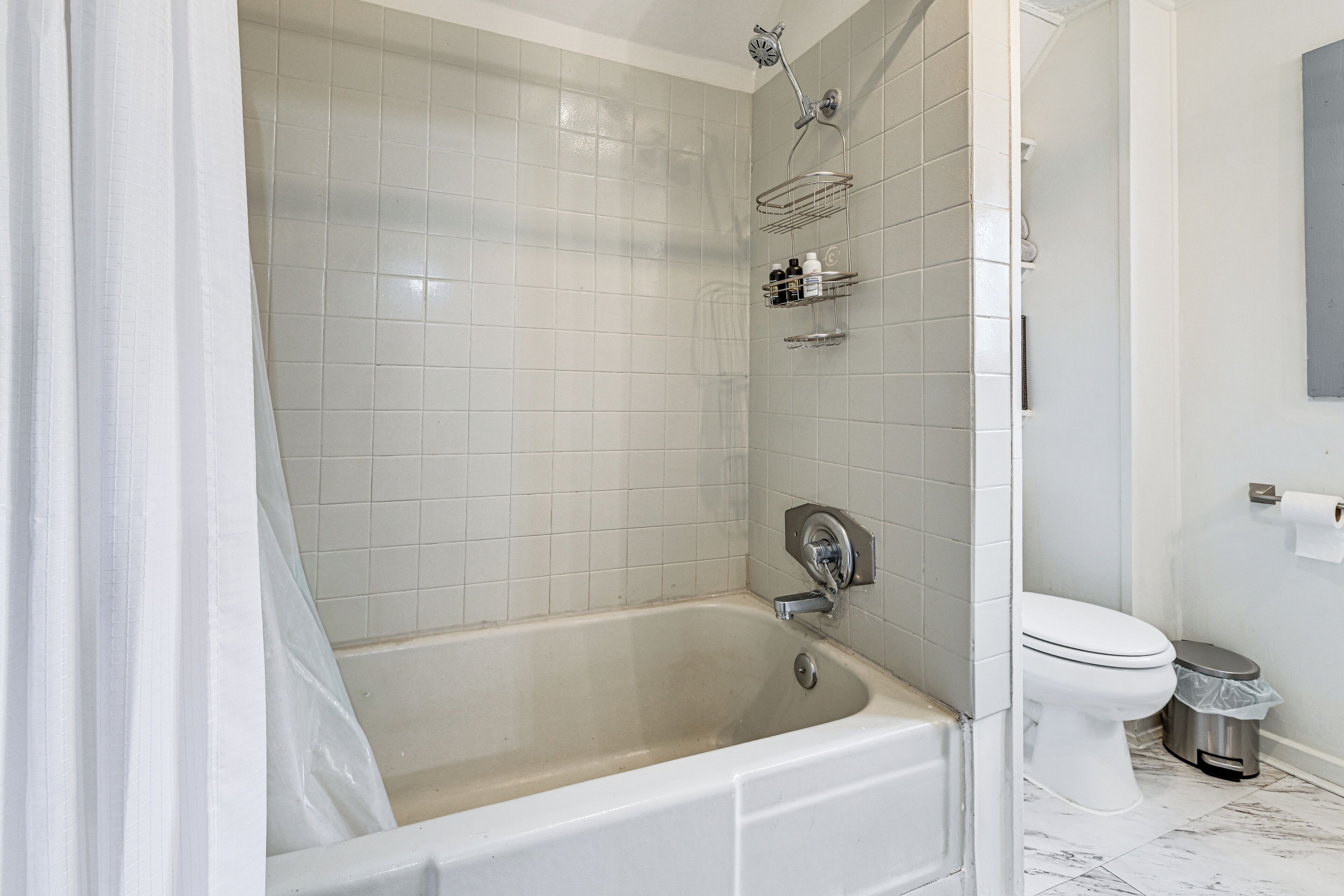 A bathroom with a bathtub, toilet, and a shower.