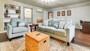 A living room with a grey sofa, a wooden coffee table, and a wicker basket. - 1 Mi to Rogue River: Walkable Grants Pass Retreat (Grants Pass)
