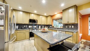 A modern kitchen with stainless steel appliances, a granite countertop, and beige cabinetry. - Pet-friendly Seatac Retreat 6 Mi to Puget Sound! (SeaTac)