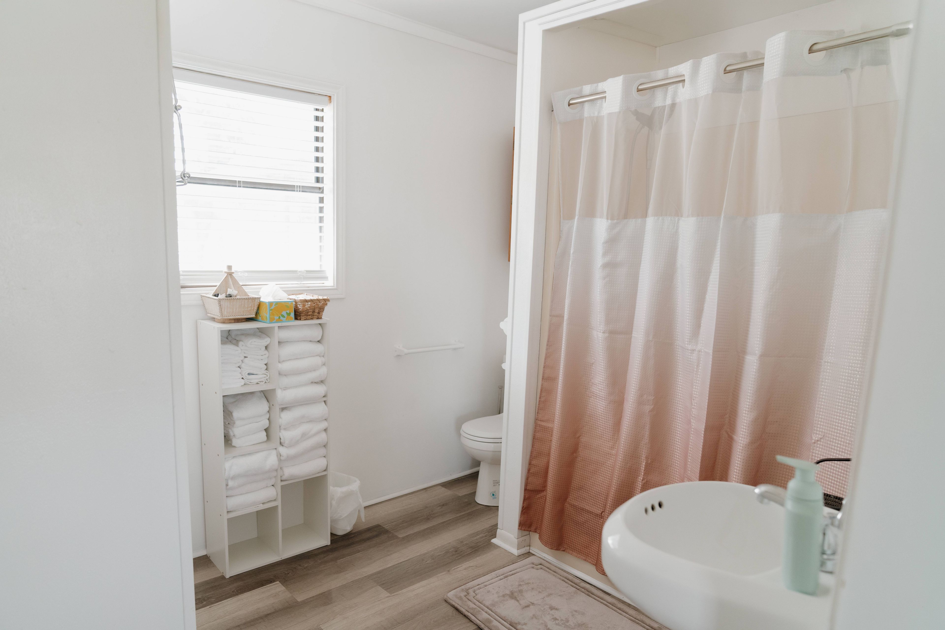 Ein Badezimmer mit Toilette, Waschbecken, Duschvorhang und Handtuchhalter.