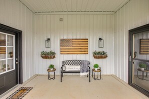 A covered porch with a bench, potted plants, and a welcome sign. - Spacious Patio & Yard! Family Home in Byrdstown (Byrdstown)