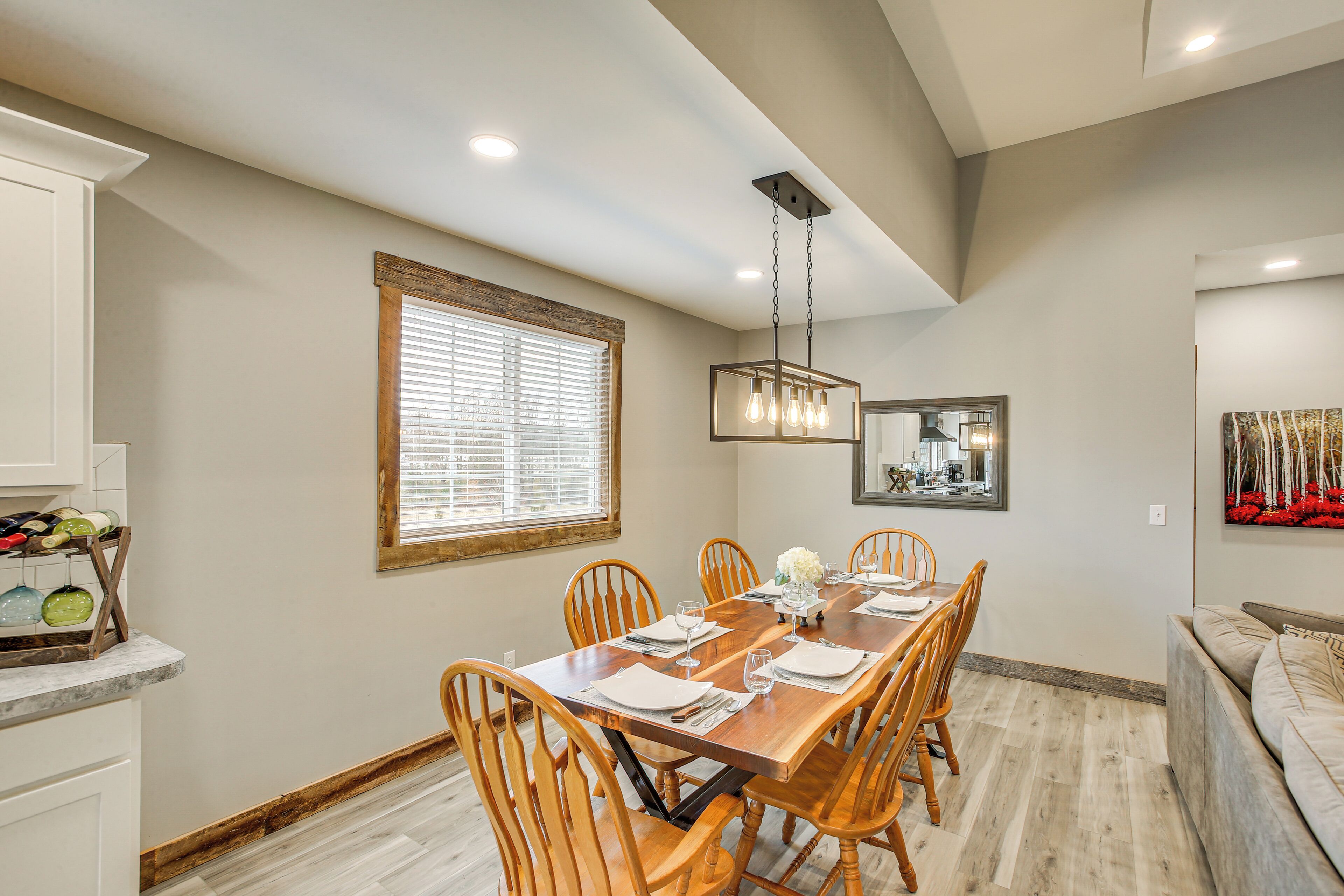 A dining area with a wooden table, chairs, and a chandelier.