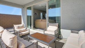 A rooftop terrace with outdoor seating, a sliding glass door leading to an indoor area, and a view of the sky. - Serene Outdoor Space: Group Getaway in Maricopa! (Maricopa)