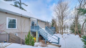 Une maison à deux étages avec un escalier bleu menant à une terrasse.