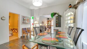 Un coin repas avec une table en verre, des chaises et un lustre.