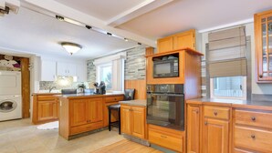 Una cucina moderna con mobili in legno, un forno a microonde integrato e un forno in acciaio inossidabile.