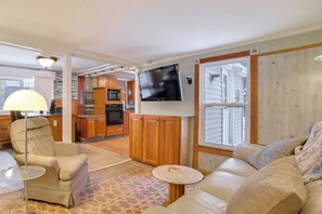 A cozy RV interior with a living area, kitchen, and a TV mounted on the wall. - Boyne Mtn Adventure Hub 4 Mi to Slopes & Golf (Boyne City)