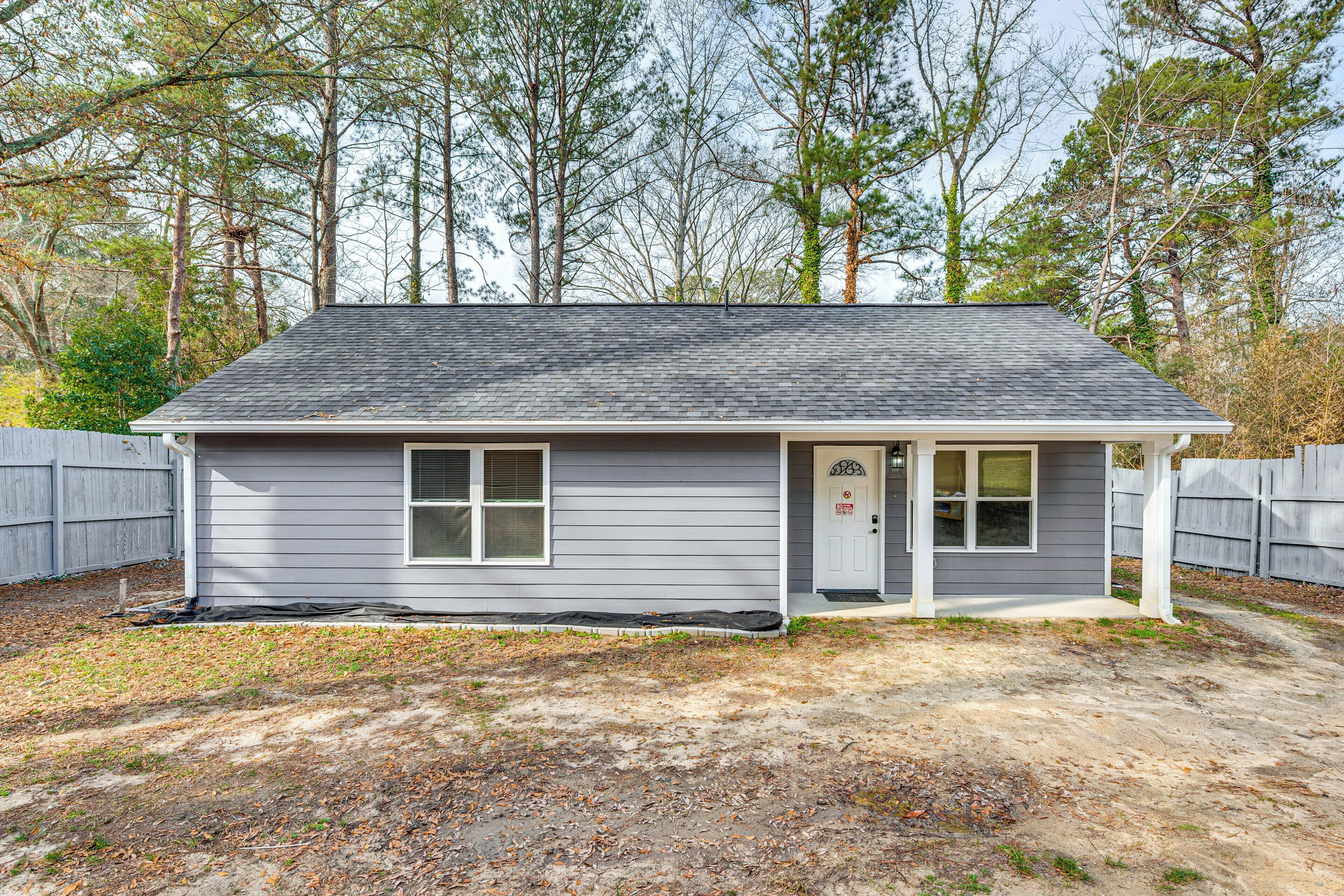 A single-story house with a gray exterior, a front door, and a small porch.