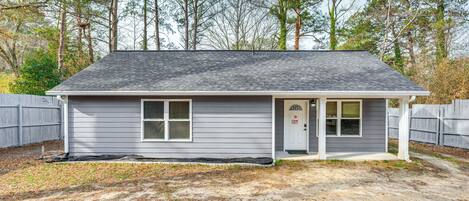 A single-story house with a gray exterior, a front door, and a small porch.