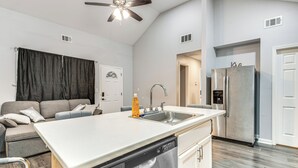 A modern kitchen with a dishwasher, stainless steel refrigerator, and a large island with a sink. - Easy I-85 Access! Quiet Fairburn Extended Stay (Fairburn)