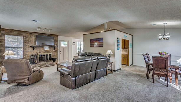A spacious living room with a fireplace, leather recliner, and dining area. - Beach Gear & Cruiser Bicycles: Quiet Pensacola Gem (Pensacola)