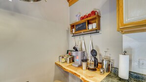A kitchen with a wooden countertop, coffee maker, kettle, and a shelf with mugs and a sign that says "Welcome". - Bring Your Boat! Woodsy Cottage Near Fayetteville (Fayetteville)