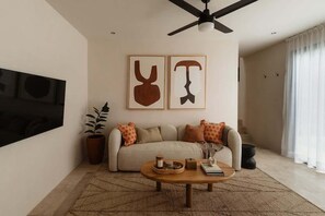 Ein Wohnzimmer mit einer Couch, einem Couchtisch und Kunstwerken an der Wand.
