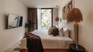 Ein modernes Schlafzimmer mit einem großen Bett, einem Fernseher, einer Topfpflanze und einem Ausblick durch ein Fenster.