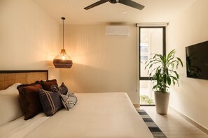 A bedroom with a bed, a ceiling fan, a hanging light fixture, a potted plant, and a window. - Nahara Jungle Chic Retreat Near the Beach (Tulum)