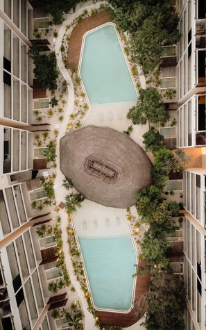 A rooftop pool area with two pools, a central seating area, and surrounding greenery. - Nahara Jungle Chic Retreat Near the Beach (Tulum)