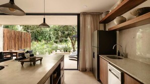 Eine moderne Küche mit großem Fenster, Holzschränken und einem eingebauten Geschirrspüler.