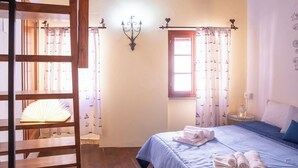 Ein Schlafzimmer mit Bett, Nachttisch, einer Deckenleuchte und einem Fenster mit Vorhängen.