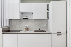 Eine moderne Küche mit weißen Schränken, einer doppelten Spüle und einer Kaffeemaschine.