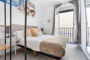 A bedroom with a bed, bedside tables, a nightstand, a wall decoration, and a balcony with curtains. - DownTown La Latina Grupos, by MoNARO (Madrid)