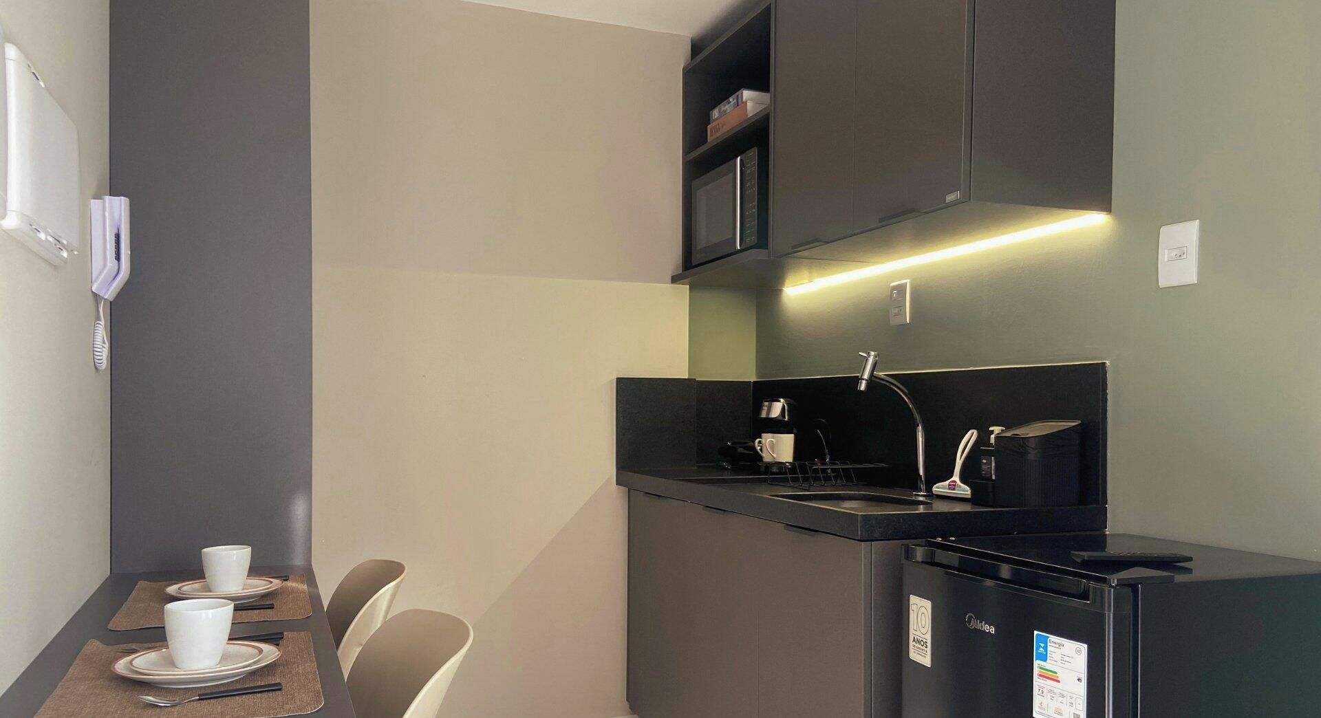 A compact kitchenette with a microwave, coffee maker, and a small refrigerator.