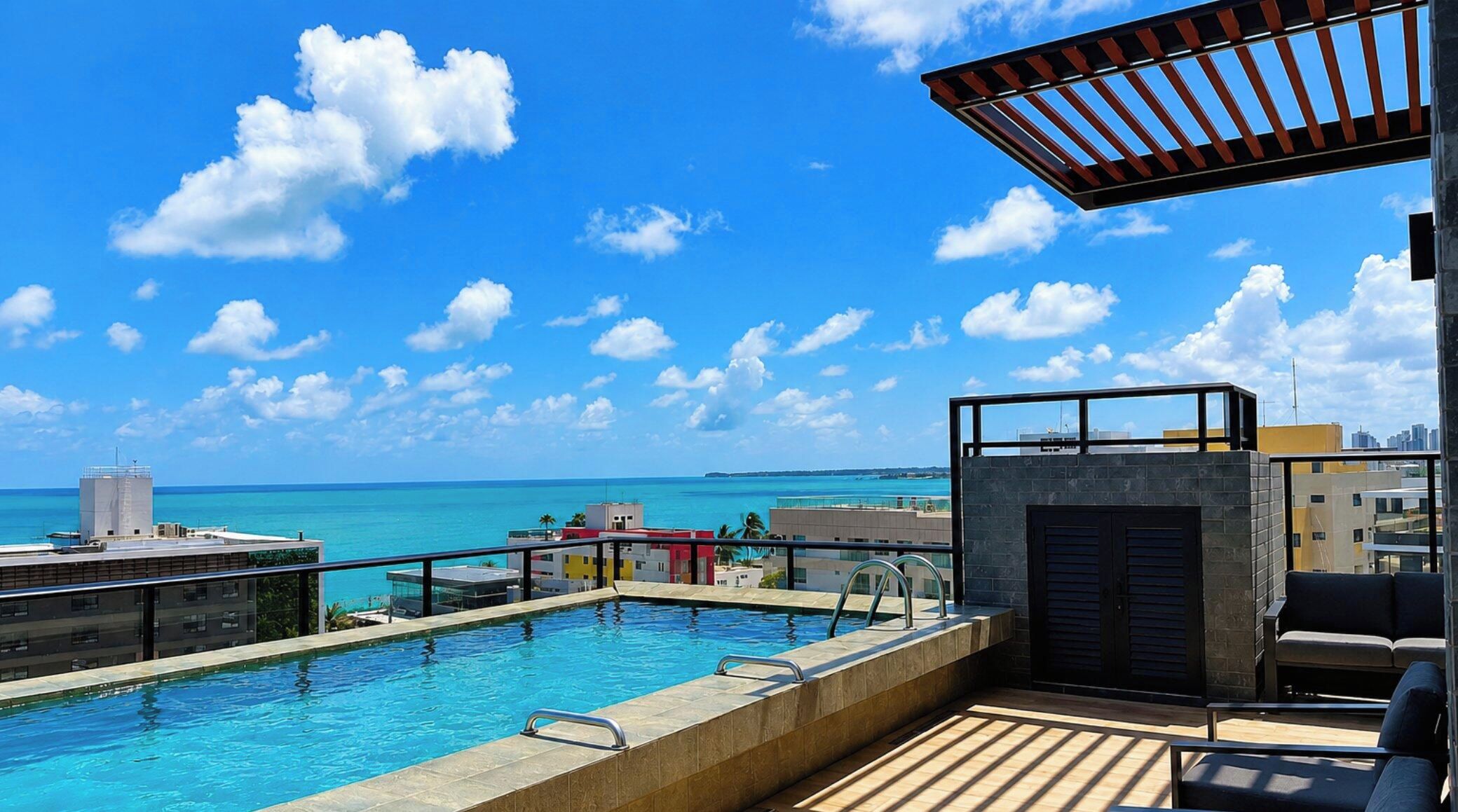 Piscina no terraço com vista para o oceano e o horizonte da cidade.