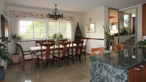 A dining area with a wooden table and chairs, a chandelier, and large windows. - 4 Bedroom Villa Sleeps 8 With Private Pool (Vera)