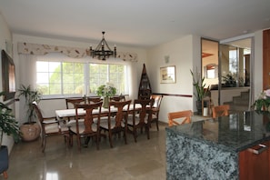 A dining area with a wooden table and chairs, a chandelier, and large windows. - 4 Bedroom Villa Sleeps 8 With Private Pool (Vera)