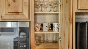 A kitchen with wooden cabinets, a microwave, and a refrigerator. - Hill Field 2 and 3 by CDH Double Town Homes (Layton)