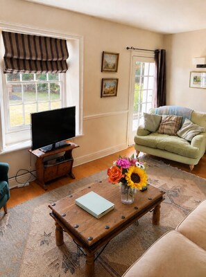 A living room with a television, sofa, coffee table, and artwork on the walls. - Country House near Deal & Sandwich (Tilmanstone)