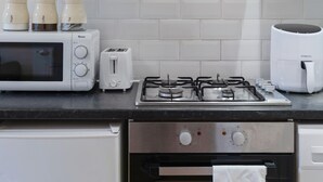 Una cocina moderna equipada con microondas, tostadora, cocina a gas y horno.