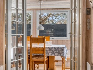 An open wooden door leading to a dining area with a table, chairs, and a hanging light fixture. - "Irma" - 300m from the sea by Interhome (Hadsund)