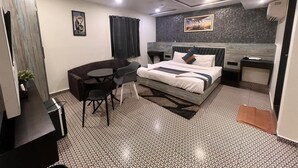 Ein modernes Hotelzimmer mit einem Bett, einem Schreibtisch, einem Stuhl und einem kleinen Tisch.