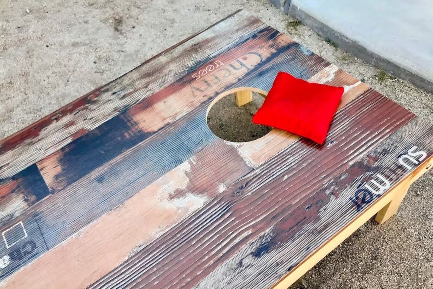 A rustic wooden table with a red cushion and a hole in the center.
