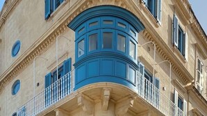 Una esquina de un edificio con ventanal saliente y balcones.
