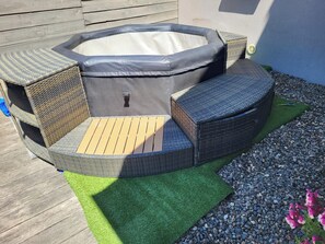 A hot tub with a wooden deck and wicker furniture. - HOUSE IN THE HAUTES-PYRÉNÉES (65260) IN VILLELONGUE WITH A SWIMMING POOL (Villelongue)