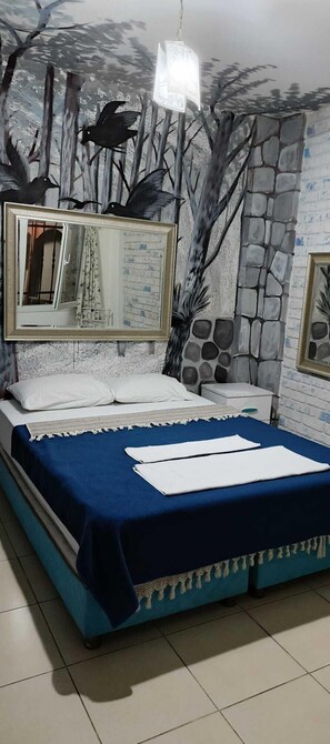 Una camera da letto con un letto, un comodino, uno specchio e un affresco sulla parete.