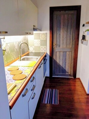 Eine Küche mit Holzarbeitsplatte, Spüle und einer Tür mit Holzrahmen.