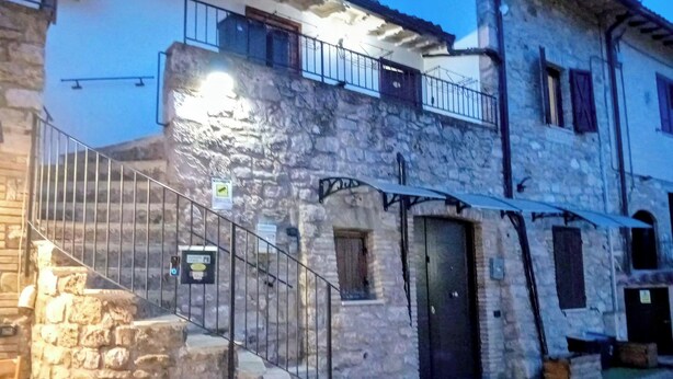 Um edifício de pedra com uma escadaria que leva a uma varanda.
