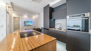 Een moderne keuken met een houten eiland, inbouwapparatuur en uitzicht op de stad.