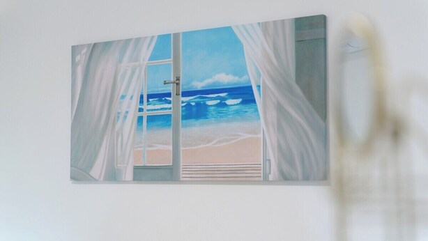 Una pintura de una escena de playa con una ventana y cortinas.