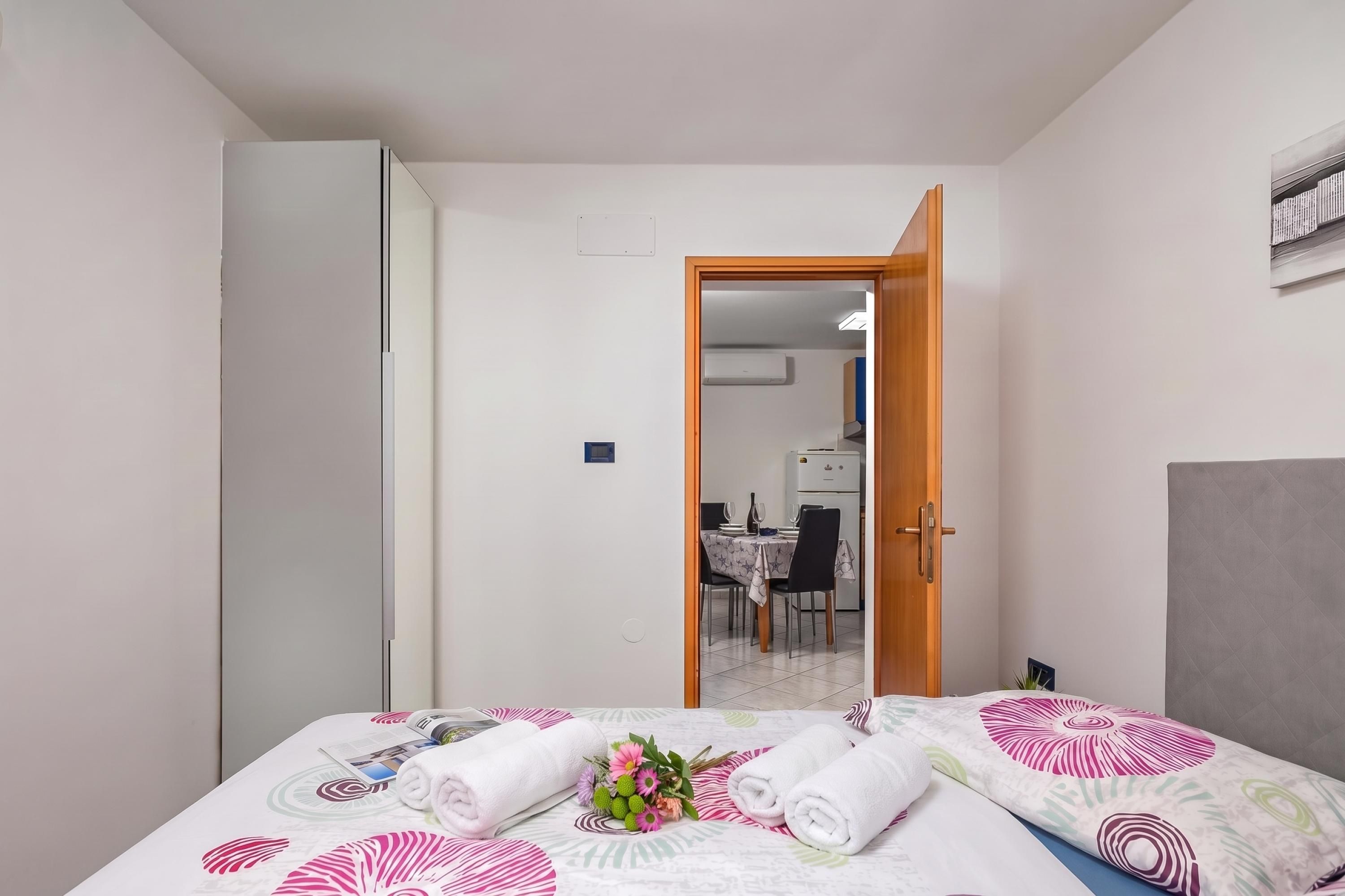 A hotel room with a bed, a dining area, and a kitchenette.