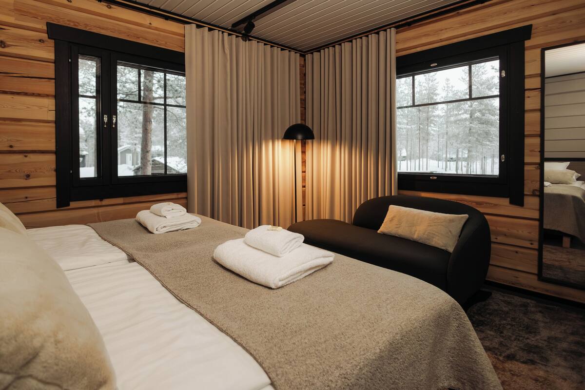 A room with a bed, a sofa, and a window with curtains.