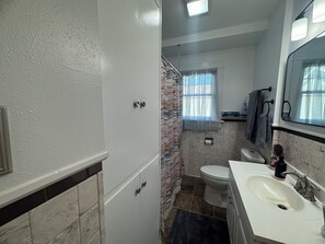 A bathroom with a toilet, sink, and shower.