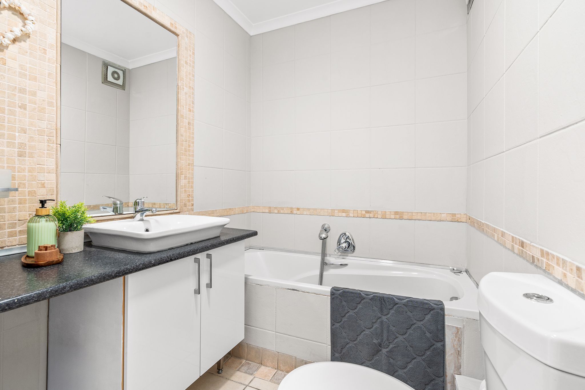 A bathroom with a white sink, a bathtub, and a toilet.