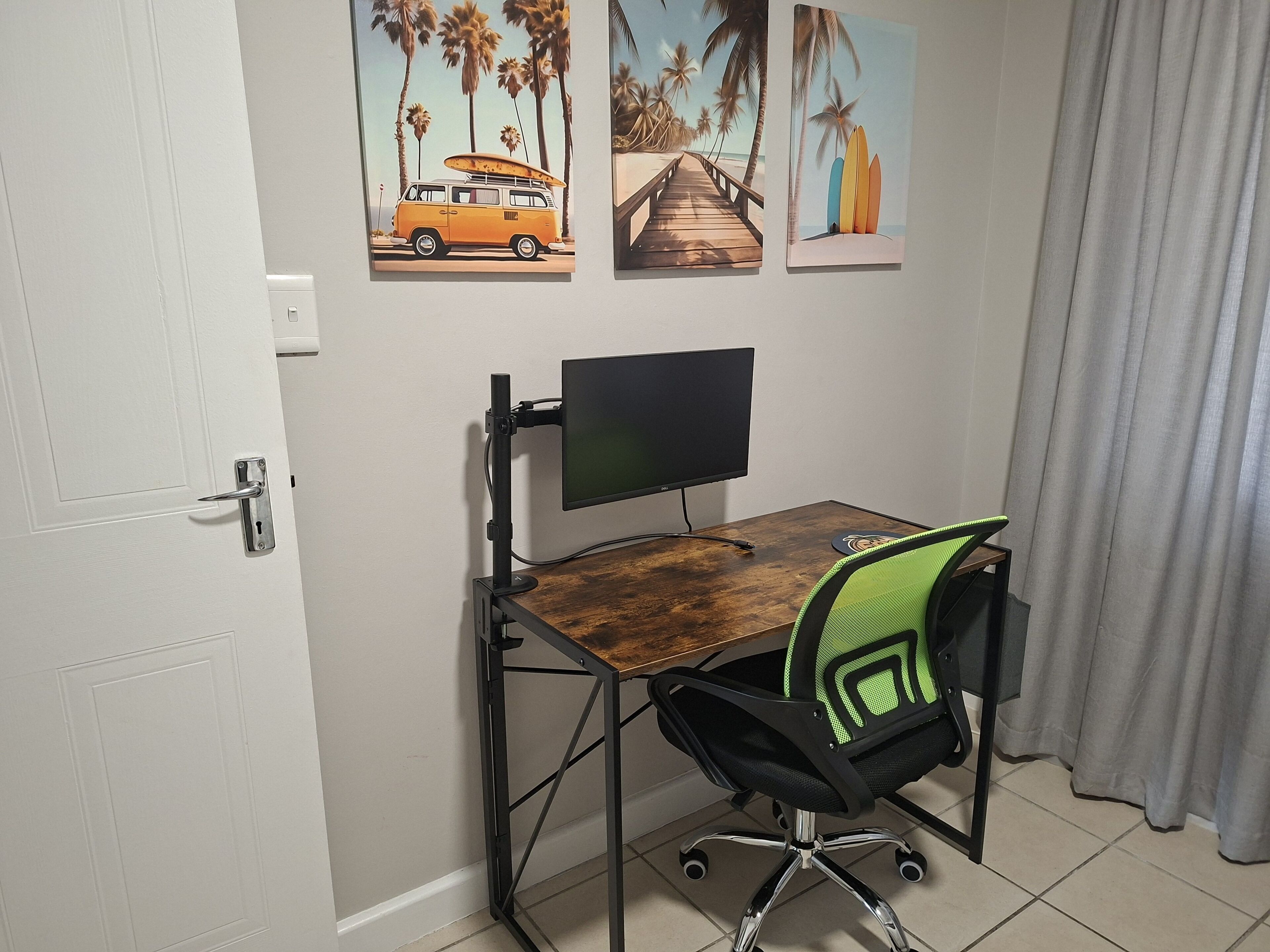 Un espacio de trabajo con escritorio, silla y monitor de computadora.