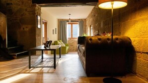 A cozy living room with a leather sofa, a coffee table, and a floor lamp. - Villa in the Ribeira Sacra, A Chalana (Pantón)