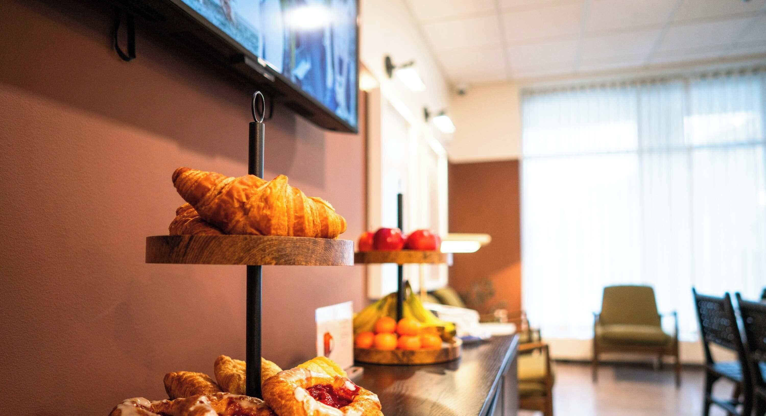 A breakfast buffet with pastries and fruits.